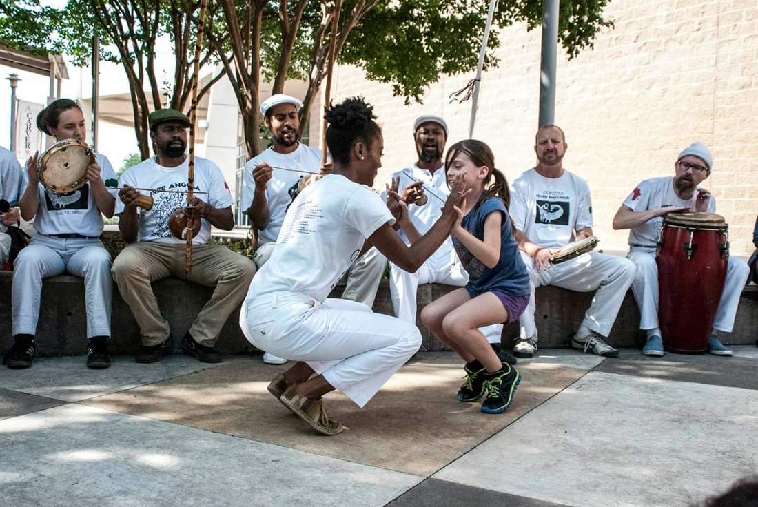 Efunsewa Layssard playing capoeira with a young student in the roda